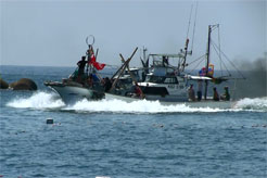 大漁旗をつけて揚場に向かう漁船