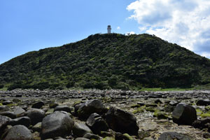 干潮時に灯台のある陸地を撮影した風景写真