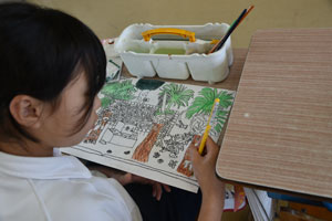 校舎をキャンバスいっぱいに描く児童